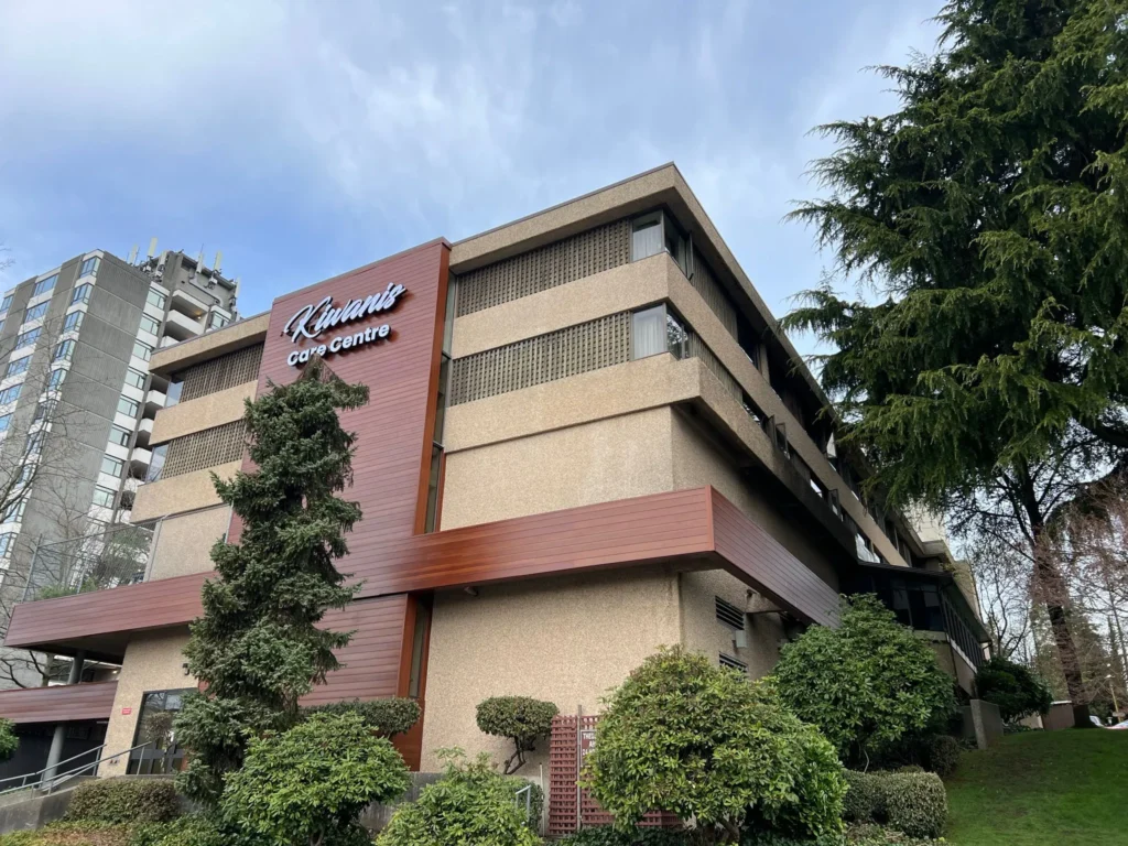 Front view of a commercial building exterior featuring Longboard wood-grain aluminum siding panels installed as a vertical accent band