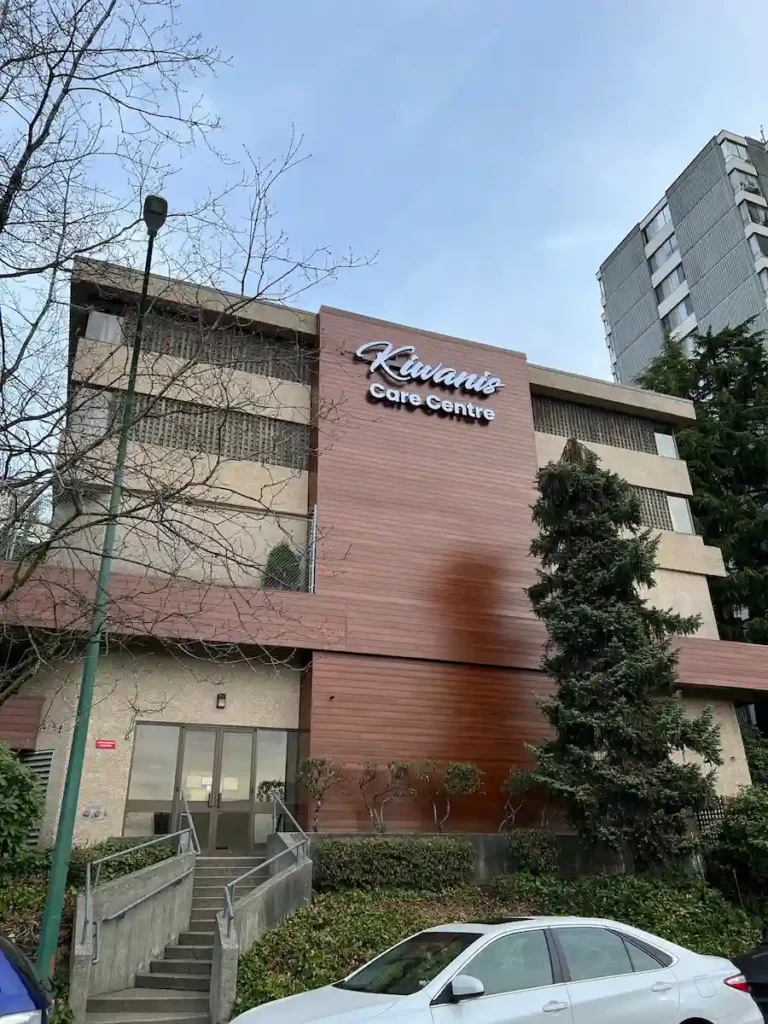 Multi-storey commercial building exterior with reddish-brown Longboard wood-look siding installed as accent bands over stucco panels